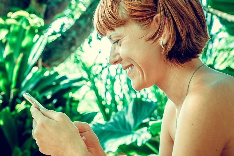 Mujer sonriendo sosteniendo un celular