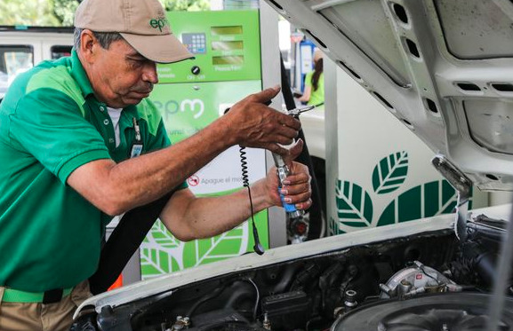 Imagen con trabajador agregando gas natural vehicular en estación de servicio