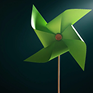 Molinillo de viento de papel verde sobre un fondo oscuro iluminado